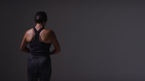 Studio-Shot-Showing-Back-Of-Mature-Woman-Wearing-Gym-Fitness-Clothing-Doing-Stretching-Exercises-1