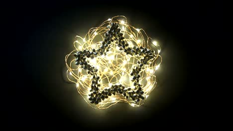 Loop video greetings card with Happy New Year writing animation on glowing yellow garland on metal bell decoration on dark background
