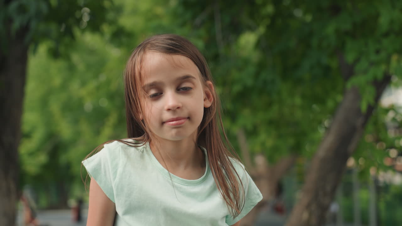 Retrato de filha multirracial em parque verde, close-up com olhar direto e cabelo cacheado trançado, camisa menta e árvores com bokeh suave, luz natural e expressão calma, atmosfera de momento em família.