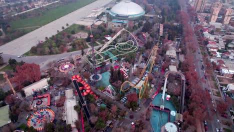 Vista-Aérea-Inclinada-Hacia-Abajo-De-Un-Parque-De-Diversiones-Con-Atracciones-Para-Toda-La-Familia,-Santiago,-Chile