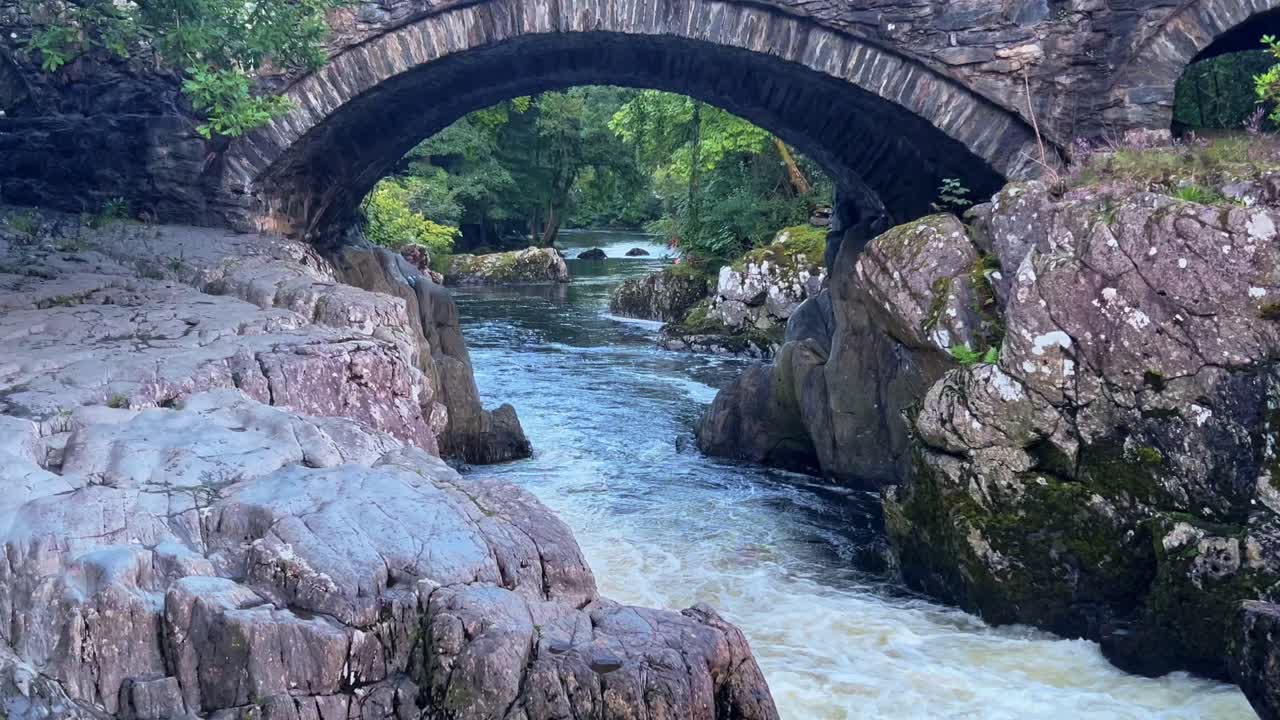 역사적인 pont y pair 돌 다리는 betws-y-coed 웨일즈에서 conwy 강을 가로지르고 있습니다.