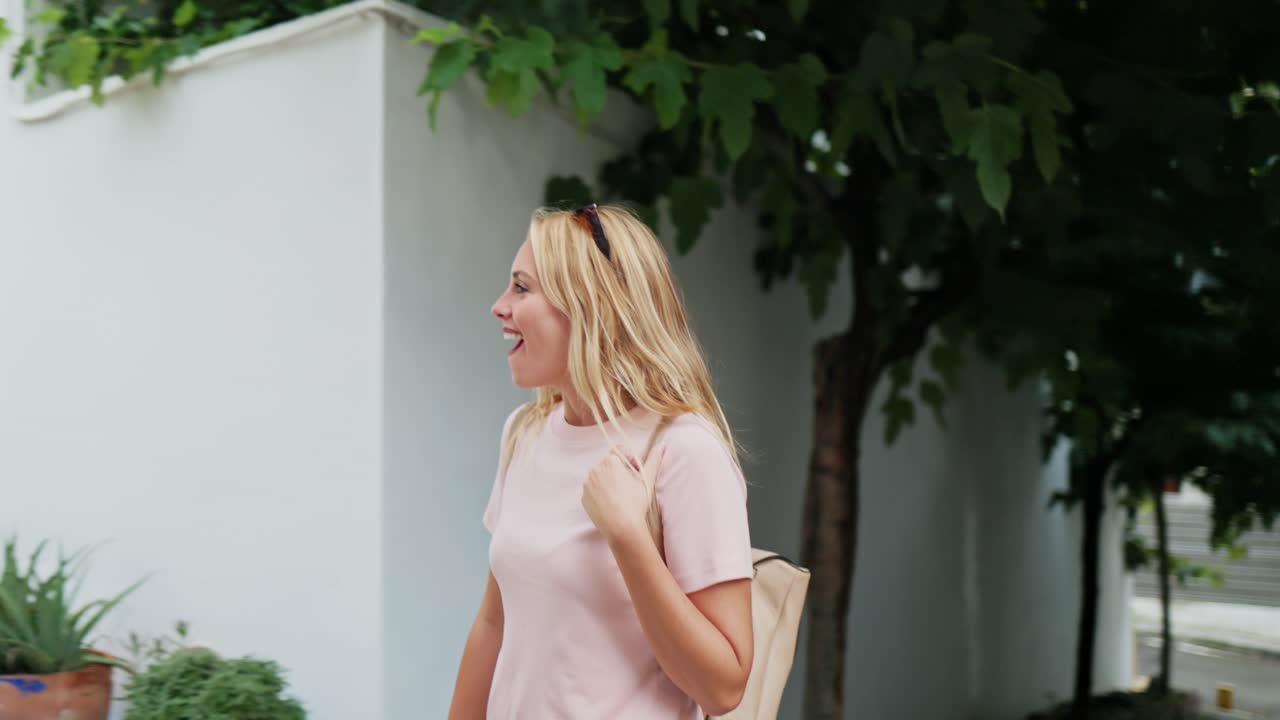 Giovane donna felice che passeggia ed esplora una pittoresca via di una città europea