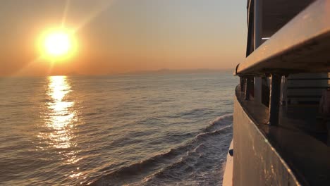 Cinematic-view-from-the-side-of-a-cruise-ship-navigating-on-the-Mediterranean-Sea-at-sunset