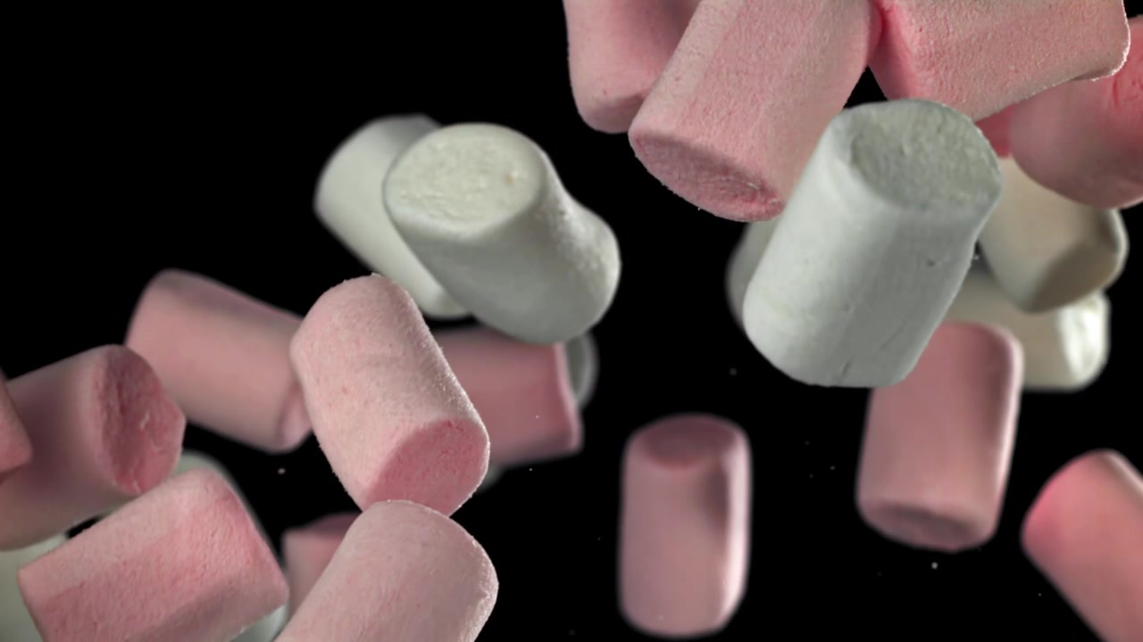 Marshmallow rosa e bianchi che cadono al rallentatore