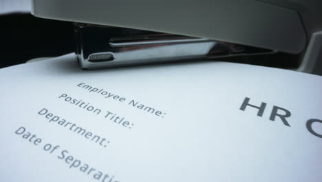 clerk stapling contract in office. person fastening documents with stapler