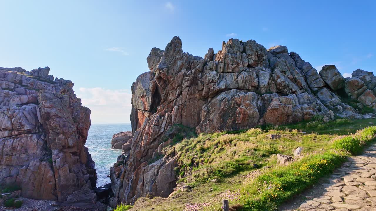 Rugged coastal Plougrescant peninsula cliffs aka Le gouffre de Plougrescant under bright sunny sky, Plougrescant, Brittany, France