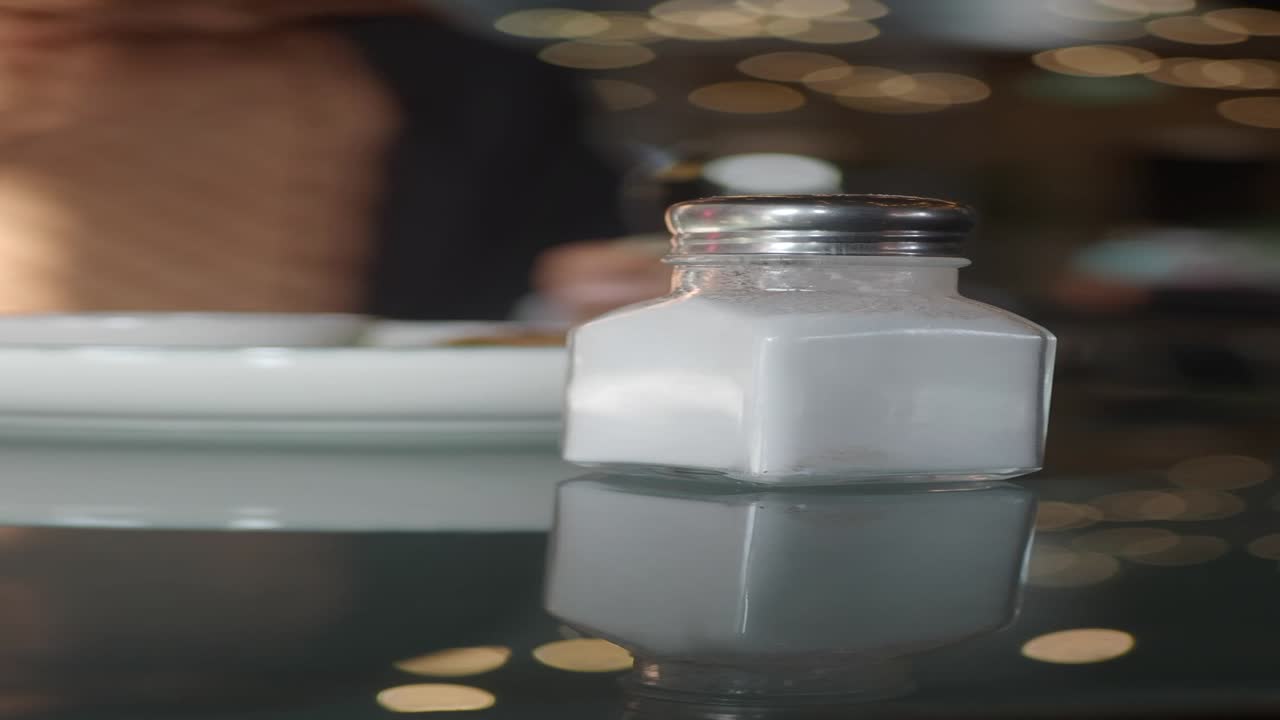 un batidor de sal en la mesa de un restaurante