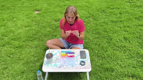 mujer con cuentas al aire libre en una mesa portátil
