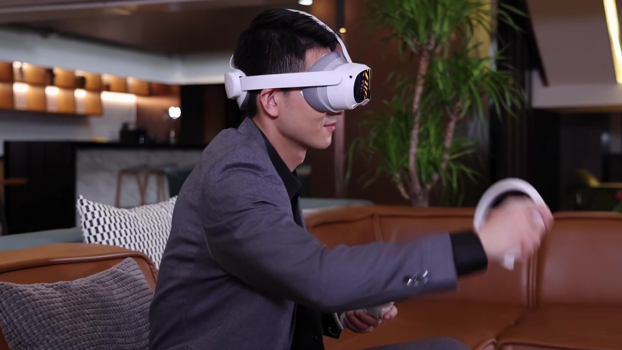 Uomo d'affari rilassato in abito che usa un visore VR di realtà virtuale guardando video a 360 gradi o giocando, controller per simulazioni di gioco, si diverte a giocare con occhiali 3D, metaverso, cyberspazio, tecnologia moderna