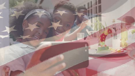 animation of american flag over family having dinner and taking selfie