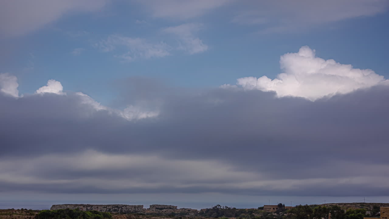 구름이 많은 날에 바위 높은 지역과 마을 집 위의 구름 움직임의 타임  ⁇ 스  ⁇