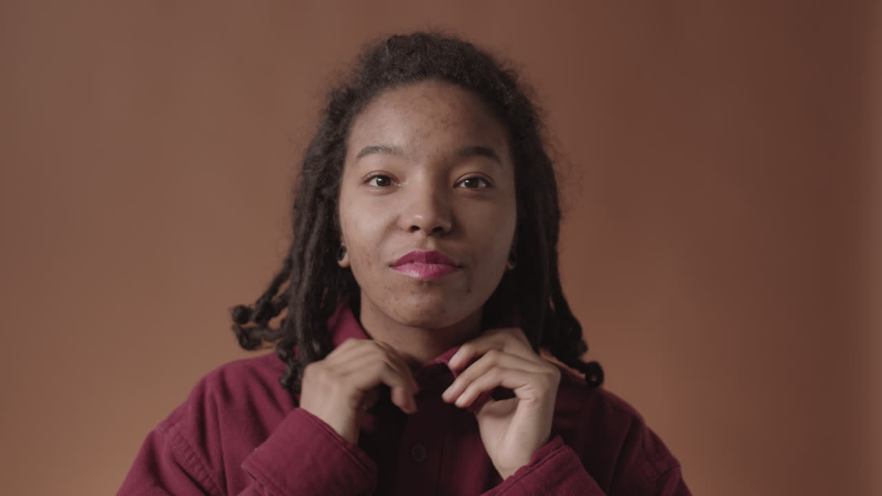 Portrait of Charming African-American Woman Fixing Shirt Collar