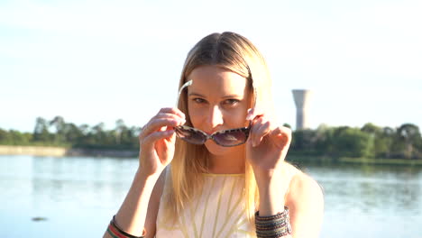 Young-woman-puts-on-sunglasses