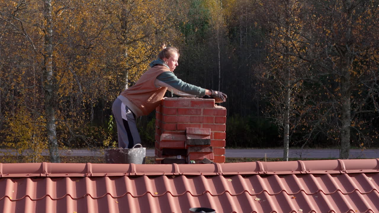 Woman Repairing a Brick Chimney on a Roof