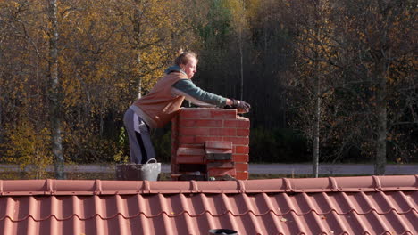 woman repairing a brick chimney on a roof