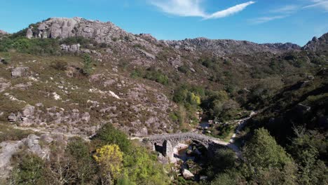 Volando-Sobre-El-Antiguo-Puente-De-Piedra-Sobre-El-Hermoso-Río