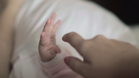 Amor-Maternal-Madre-Tocando-La-Mano-Del-Bebé