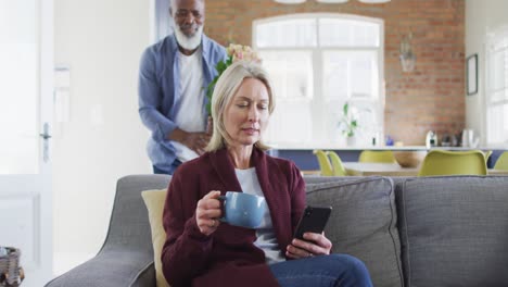 African-american-senior-man-giving-a-flower-bouquet-to-his-wife-at-home