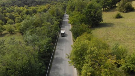 aerial shot, drone track small lorry vehicle uphill