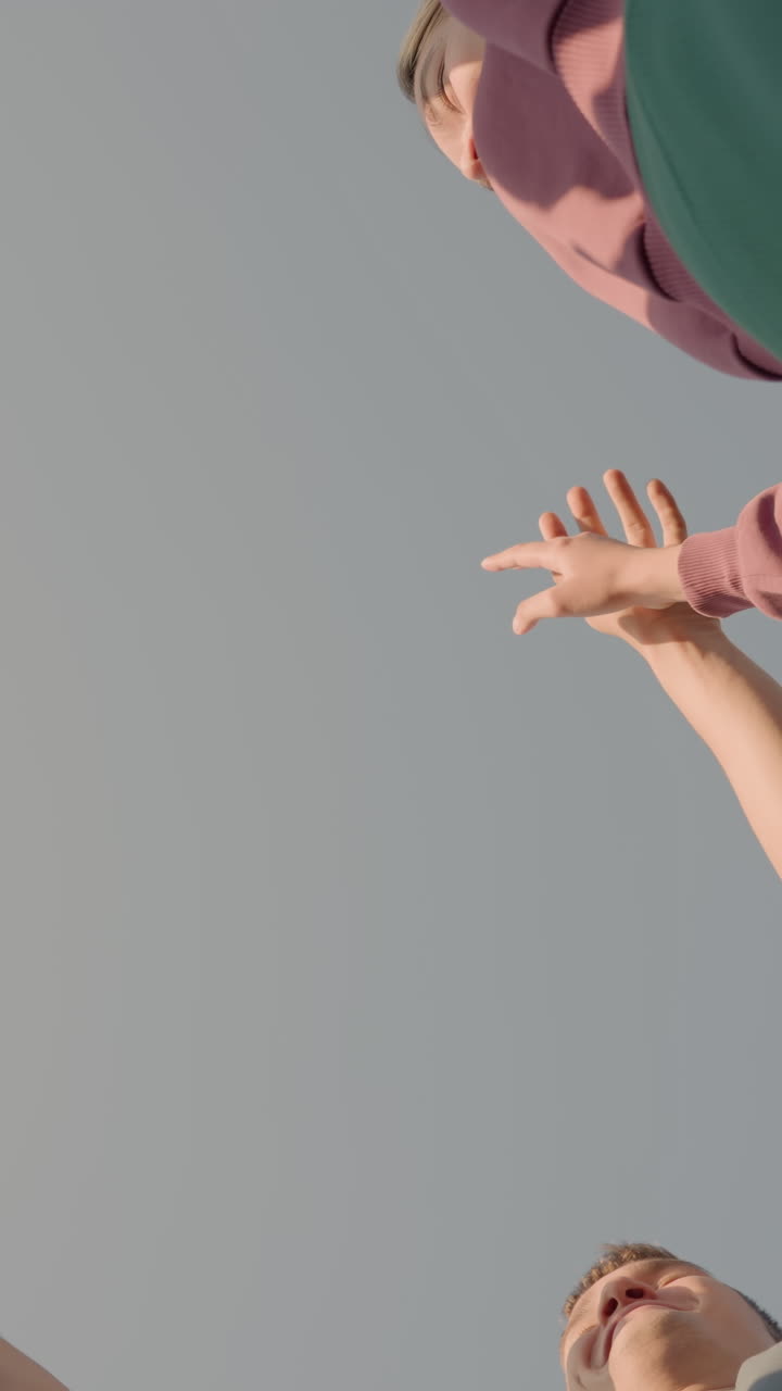 vista hacia arriba de los miembros del equipo aplaudiendo las manos mientras se unen en unidad y colaboración, capturando un momento de trabajo en equipo, energía y esfuerzo colectivo en un entorno al aire libre