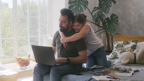 father working from home with daughter