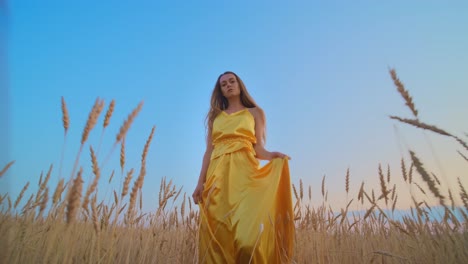woman in yellow dress in a wheat field at sunset