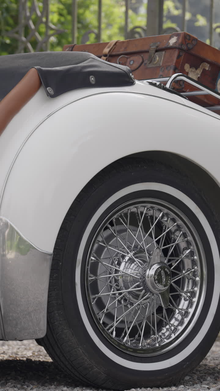 Close-up of a White Vintage Car with Spoke Wheel and Luggage