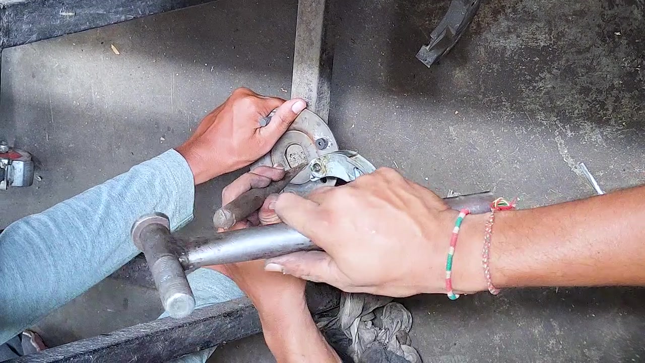 Close-up of mechanics hammering and adjusting automobile brake component during repair in workshop. Ideal for automotive maintenance, repair service, engineering, and DIY content.