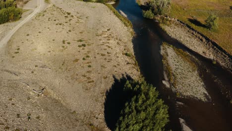 aerial tilt up shot of a river in the countryside of new zealand