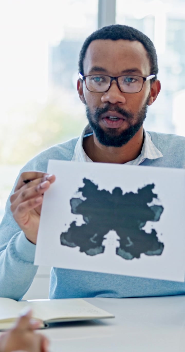 Psicologo che mostra il test di Rorschach delle macchie d'inchiostro al paziente durante una seduta di terapia