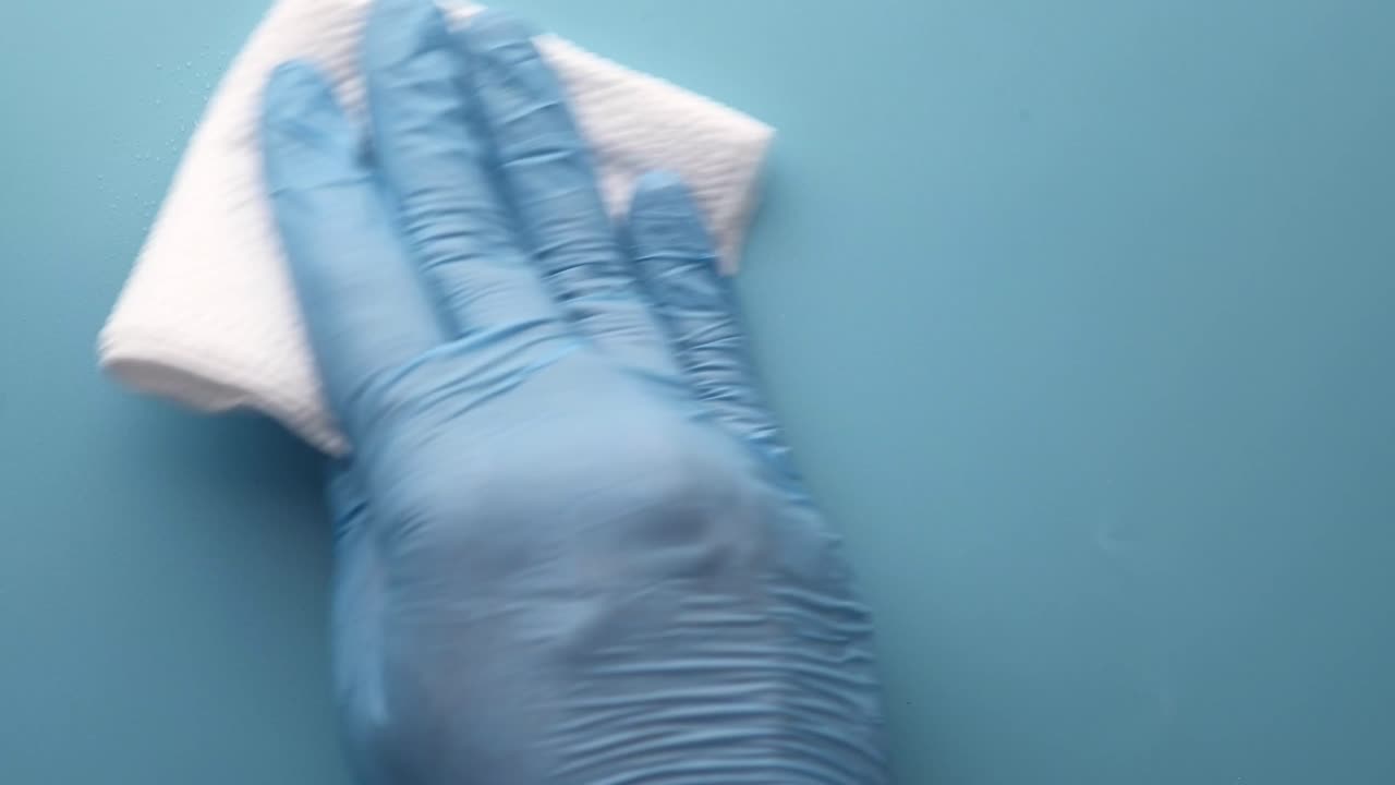 limpieza de una superficie con guantes y un paño