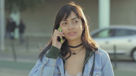 chica adolescente relajada hablando en el teléfono inteligente con un amigo.