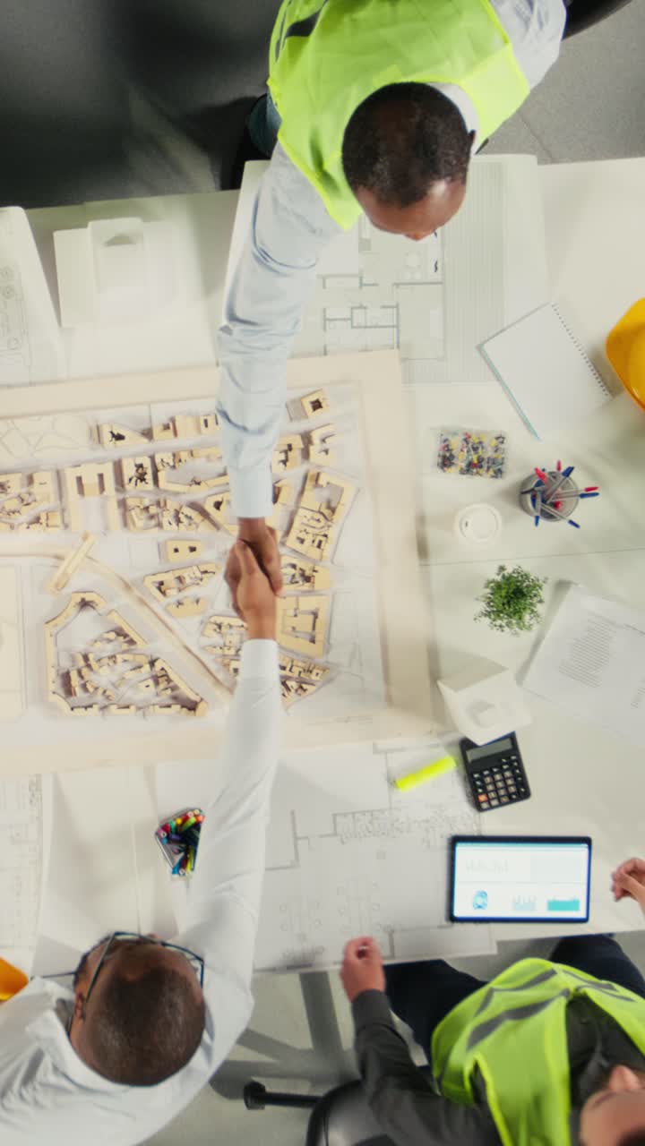 Vertical Video Top down view zoom in of developers and architects in business meeting