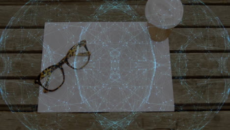 Flat design showing blank paper on wooden table with tortoiseshell glasses, coffee, network overlay