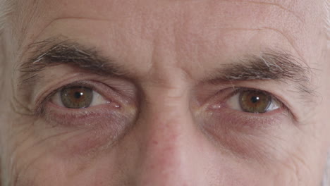 close up middle aged man eyes opening looking at camera aging wrinkles