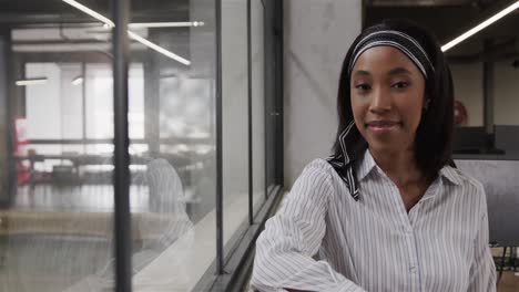 portrait of happy african american casual businesswoman in office, copy space, slow motion