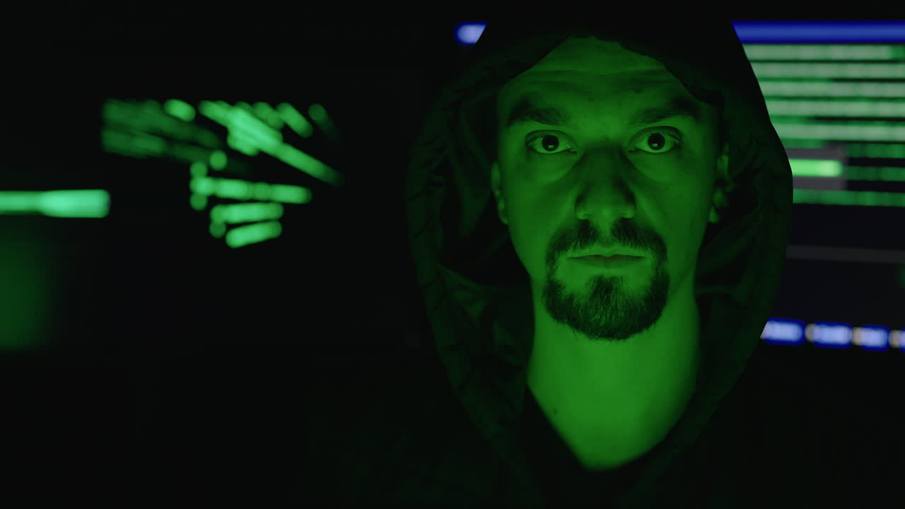 Hacker in hoodie with code background