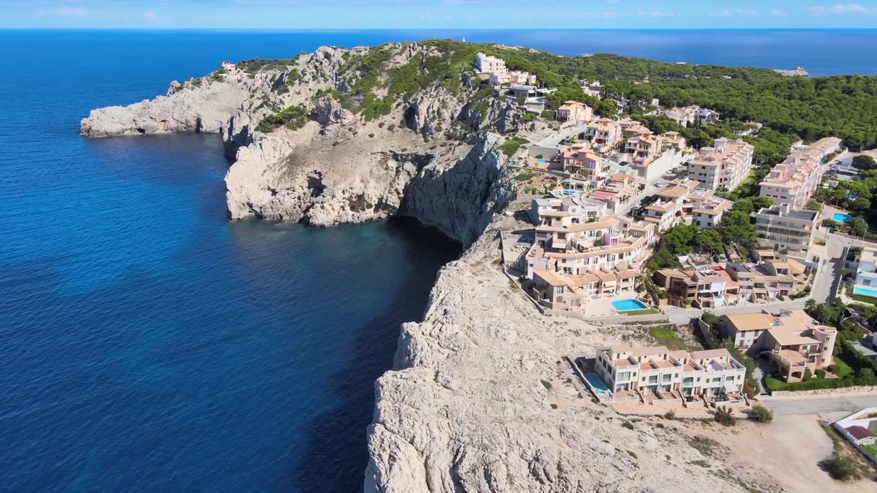 Explore as deslumbrantes paisagens costeiras de Cala Agulla em Cala Rajada, Maiorca. Desfrute das águas azuis cristalinas e das falésias de tirar o fôlego enquanto o sol brilha intensamente neste local pitoresco