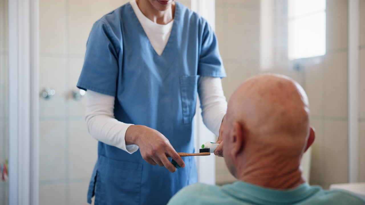 Nurse helping senior man brush his teeth