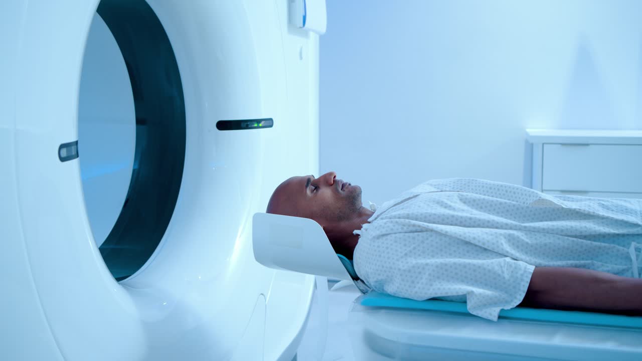 Il paziente è disteso su un lettino motorizzato mentre lo scanner si avvia e posiziona la testa per l'imaging.