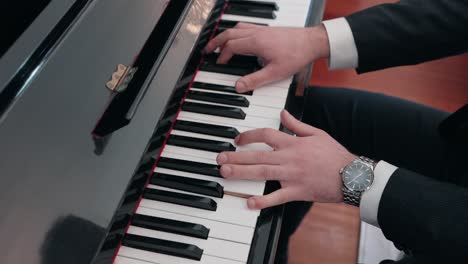 elegant man in suit playing piano with focus on hands in portugal