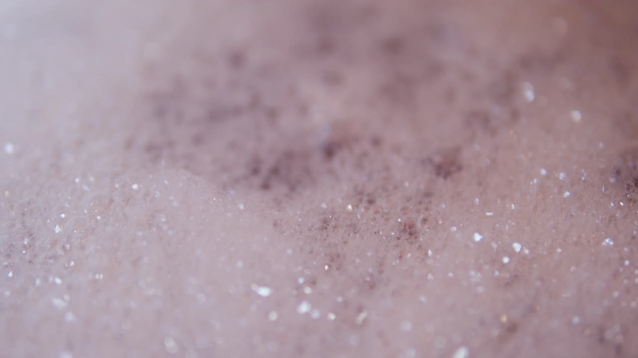 Close up view of foam and soapy bubbles on a moving water surface, self care, bathtub, background