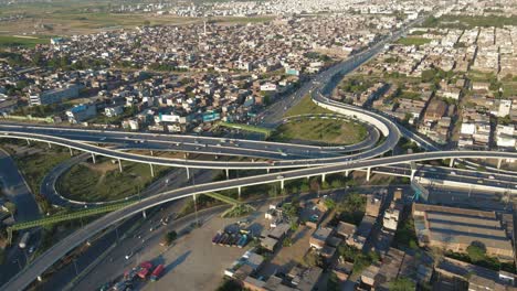 4k:-Drone-flying-over-the-small-city-of-Punjab-in-Pakistan,-view-of-traffic-flyover-and-urban-traffic