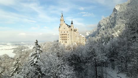 drone volando hacia el castillo de neuschwanstein en füssen en invierno nevado