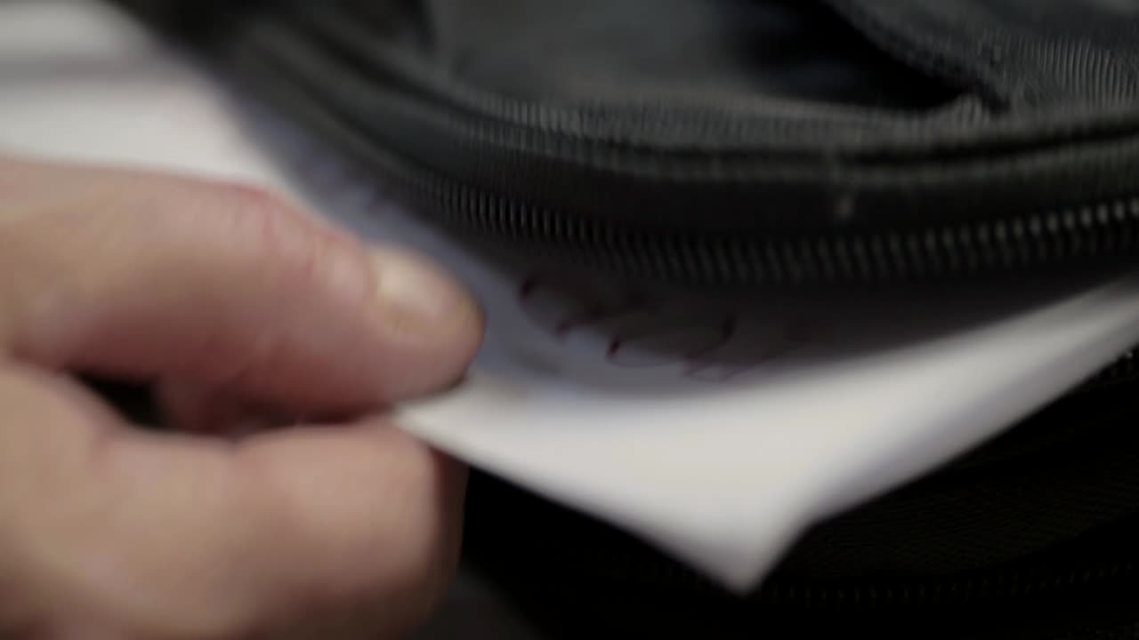 서류 가방에서 기밀 정보가 포함된 일급 비밀 문서를 꺼내는 손