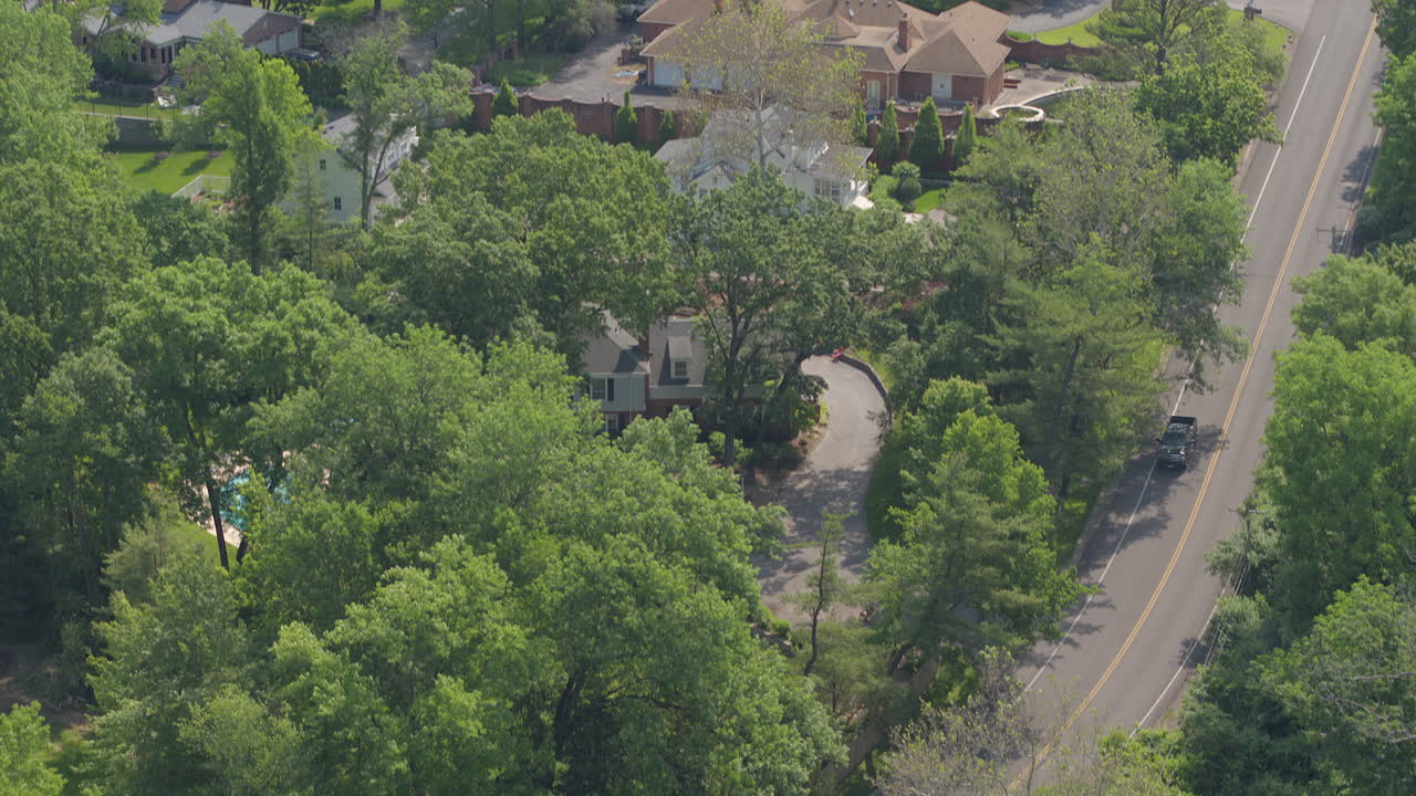 inclínate hacia abajo para seguir una camioneta en una carretera en un hermoso vecindario en un día de verano
