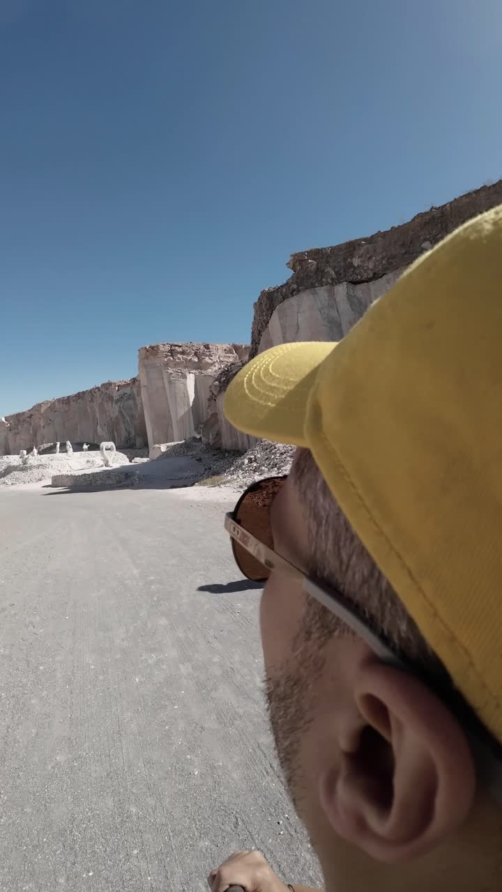 Vista in prima persona di un uomo che esplora una grande cava di pietra.
