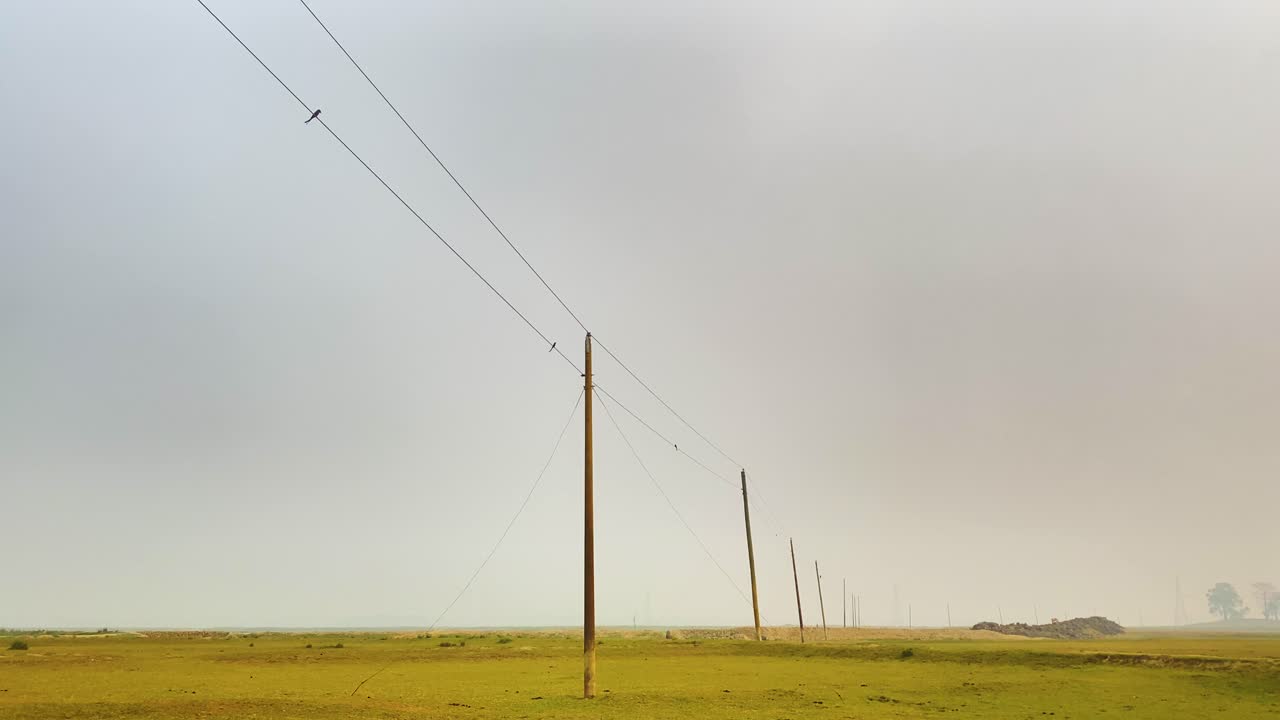 una toma panorámica de una línea eléctrica rural en un paisaje remoto de bangladesh, que muestra el concepto de desarrollo en las zonas rurales