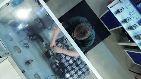Worker fixing metal detail in vice grip in production shop. Manual processing