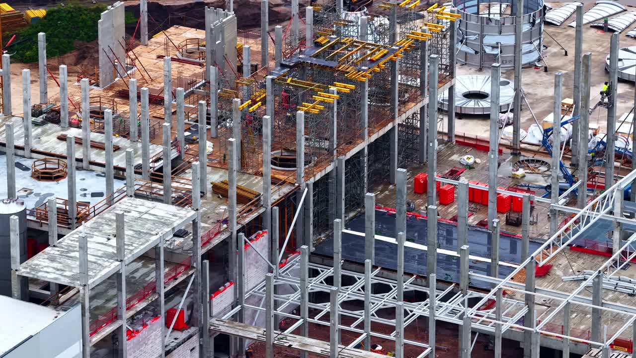 Workers are Constructing a Large Multi-story Building With Steel Frameworks and Concrete Structures - Panning Shot